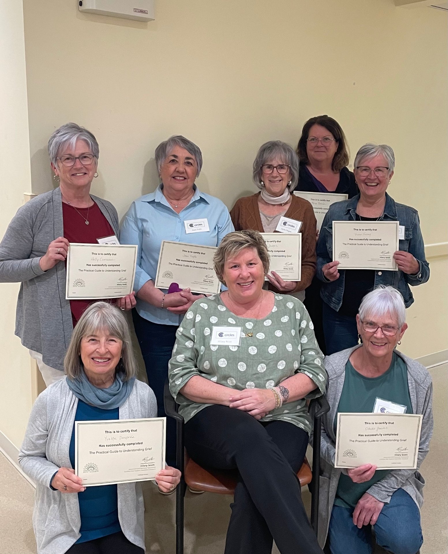 Circles of Grief team holding their Practical Guide to Understanding Grief certificates